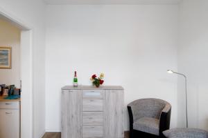 a room with two chairs and a wooden dresser at 'kiek In' Fewo Schellberg in Grevesmühlen