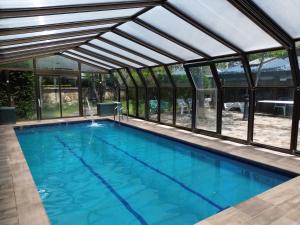 an indoor swimming pool with a glass house at Casa Rural Los Ciegos in Peguerinos