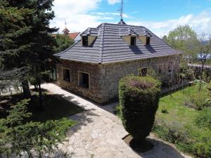 a stone house with a shingled roof at Casa Rural Los Ciegos in Peguerinos