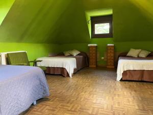 a green room with three beds and a window at Casa Rural Los Ciegos in Peguerinos +25 photos
