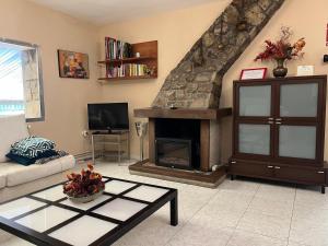 a living room with a couch and a fireplace at Casa Rural Los Ciegos in Peguerinos