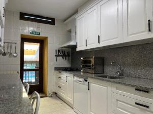 a kitchen with white cabinets and a counter top at Casa Rural Los Ciegos in Peguerinos
