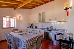 a kitchen with a table with a bowl of fruit on it at Villa Oliva Al in Moncarapacho