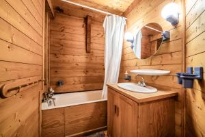 a bathroom with a sink and a mirror and a tub at La Rissole - Chalet familial in Châtel +25 photos