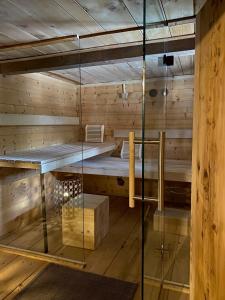 a sauna with wooden walls and a glass wall at Landhaus Gustl in Chieming +19 photos