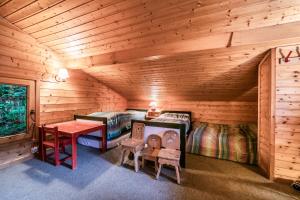a log cabin bedroom with two beds and a table at La Rissole - Chalet familial in Châtel