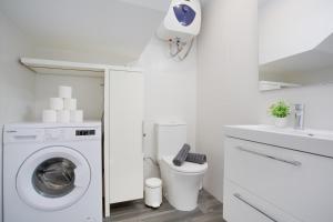 a white laundry room with a washing machine and a sink at Casa Judit in Los Silos