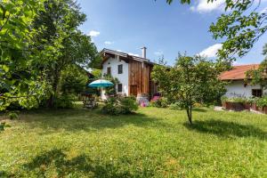 a garden with a house and an umbrella at Landhaus Gustl in Chieming