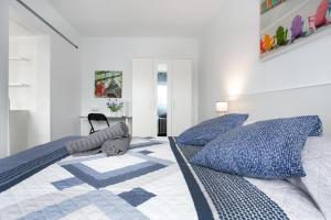 a white bedroom with a bed with blue pillows at Casa Judit in Los Silos