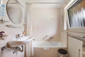 a bathroom with a sink and a shower and a tub at Abendrot in Münsingen +21 photos