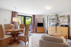 a living room with a dining room table and a couch at An der Silberfuchsbörse in Wurster Nordseeküste