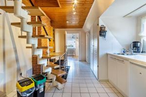 a spiral staircase in a kitchen with white cabinets at Ferienwohnung Jesteburg in Jesteburg +13 photos