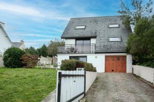 a white house with a gate and a driveway at Bellevue rue de la petite corniche in Perros-Guirec