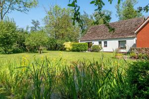 a house with a yard with grass and flowers at An der Silberfuchsbörse in Wurster Nordseeküste