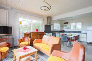a living room with orange chairs and a kitchen at Bellevue rue de la petite corniche in Perros-Guirec