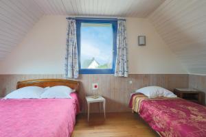 two beds in a room with a window at Bellevue rue de la petite corniche in Perros-Guirec