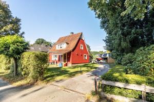 a red house on the side of a road at Ferienwohnung Jesteburg in Jesteburg