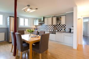 a kitchen and dining room with a table and chairs at Villa Müller Turmfalke in Ossiach +9 photos