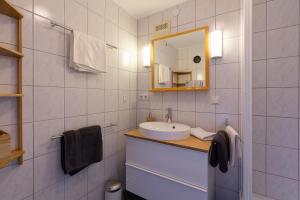 a white bathroom with a sink and a mirror at Villa Müller Turmfalke in Ossiach
