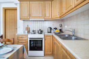 a kitchen with wooden cabinets and a white stove top oven at Panorama apartment 1 in Póndi +21 photos
