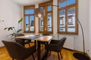 a dining room with a table and chairs and windows at Breisgau Lofts - Nähe Europapark in Herbolzheim