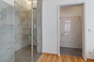 a walk in shower in a bathroom with a glass door at Breisgau Lofts - Nähe Europapark in Herbolzheim +27 photos