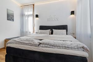 a bedroom with a large bed with white walls at Breisgau Lofts - Nähe Europapark in Herbolzheim