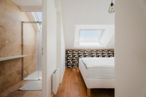 a bedroom with a bed and a walk in shower at Logement calme proche centre ville in Rennes