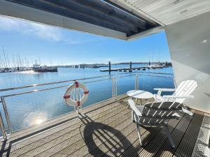 a balcony with two chairs and a table on a ship at Floating Home Nr 1 in Laboe +33 photos