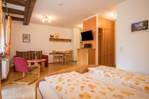 a hotel room with a bed and a dining room at Ferienwohnung Risthof 3 in Owingen