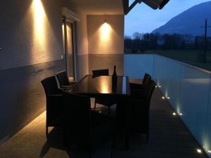 a dining table and chairs on a balcony at night at Villa Müller Rotfuchs in Ossiach