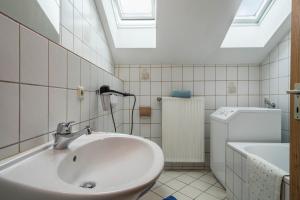 a bathroom with a sink and a skylight at Ferienwohnung Schleinseeblick in Kressbronn am Bodensee +16 photos