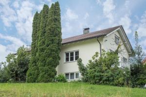 a white house with a large tree at Ferienwohnung Schleinseeblick in Kressbronn am Bodensee