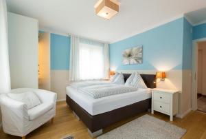 a bedroom with a bed and a white chair at Villa Müller Rotfuchs in Ossiach +14 photos