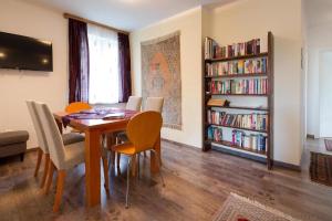 a dining room with a table and chairs and bookshelves at Villa Müller Rotfuchs in Ossiach