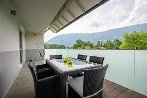 a patio with a table and chairs on a balcony at Villa Müller Rotfuchs in Ossiach