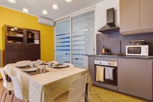 a kitchen with a table with chairs and a microwave at Residence Franciacorta in Rovato +23 photos
