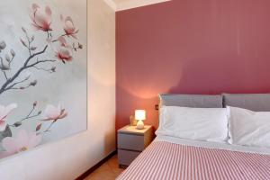 a bedroom with a red accent wall and a bed at Residence Franciacorta in Rovato