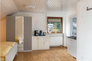 a kitchen with white cabinets and a bed in a room at Ferienwohnung Maria Feucht in Überlingen