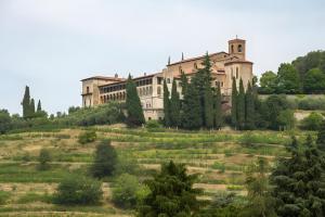 a large building on top of a hill with trees at Residence Franciacorta in Rovato