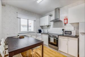 a kitchen with white cabinets and a black counter top at Casa da Travessa com 3 Quartos in Horta