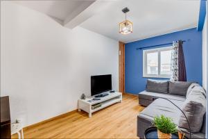 a living room with a couch and a tv at Casa da Travessa com 3 Quartos in Horta