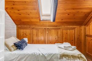 a bedroom with a bed in a wooden room with a window at Casa da Travessa com 3 Quartos in Horta