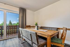 a dining room with a wooden table and a balcony at Fuchsmichelhof 3 in Seebach