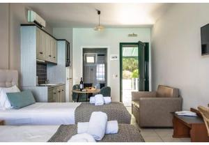 a living room with two beds and a kitchen at Sunset Triple 2 in Lefkada