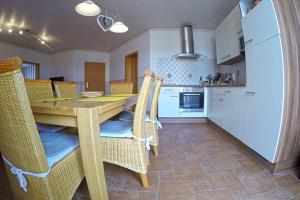 a kitchen with a wooden table and chairs at Ferienbauernhof - Ferienwohnung 5 in Grünow