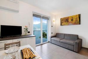a living room with a couch and a television at Appartamento 5 Il Tornante in Nesso