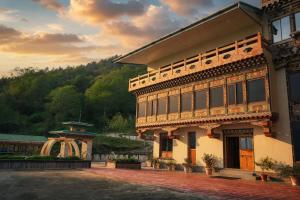 a large building with a sunset in the background at Norbu Lingka Resort in Tongsa