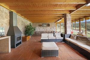 an outdoor living room with couches and a fireplace at Les Cases in Sagás