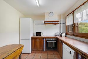 a kitchen with a white refrigerator and a counter at Les Cases in Sagás